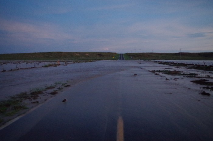 Four feet of moving water (and a warm of mosquitoes) blocking our road.